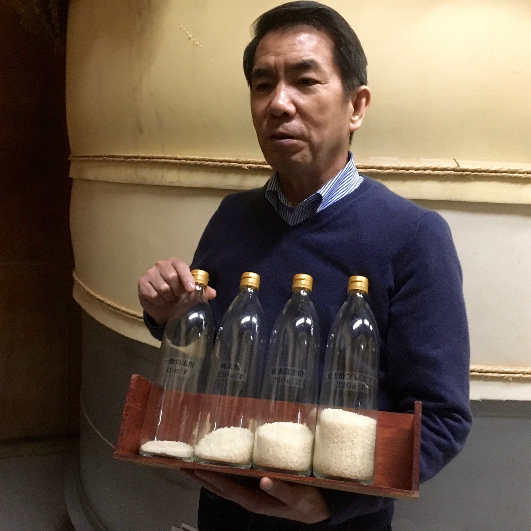 Iio-san comparing amounts of rice used to make rice vinegar