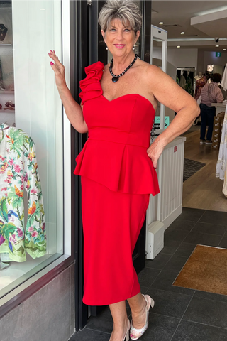 Mother of the bride wearing a red formal dress with frills and one shoulder