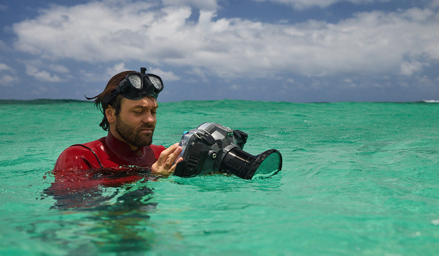 diver adjusting controls of Nikon Z9 camera in Edge Max underwater camera housing