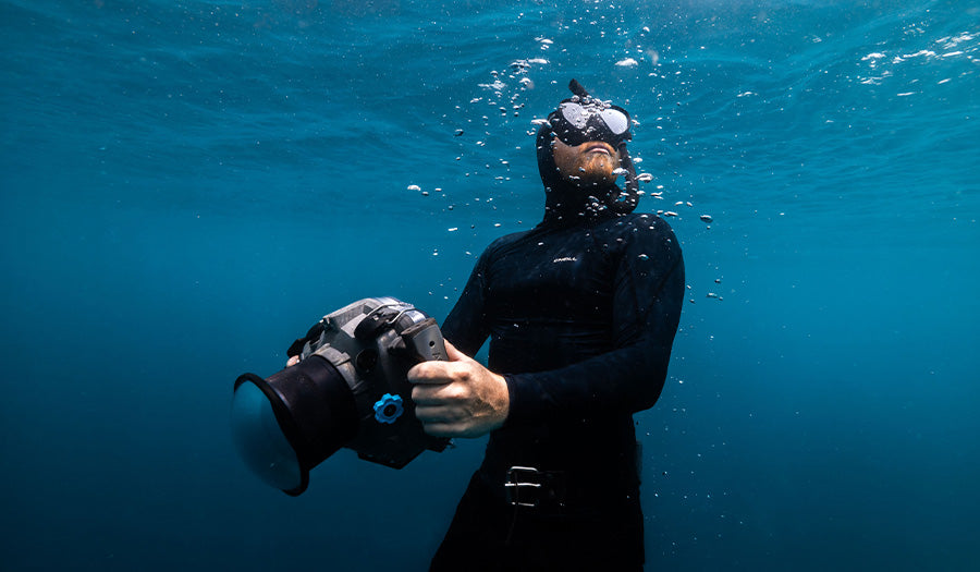 underwater photographer swimming to surface with EDGE MAX water housing for Nikon Z9