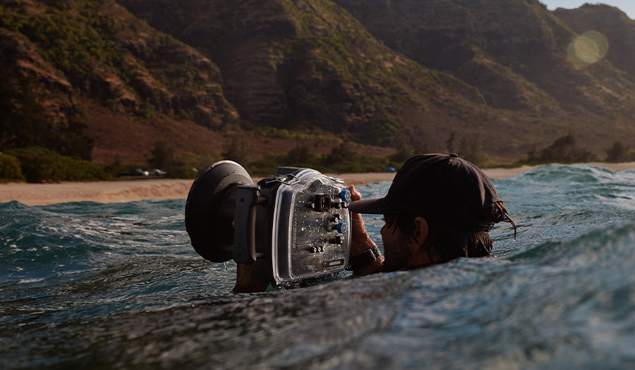 photographer in ocean with EDGE MAX water housing taking photo of Australian shoreline