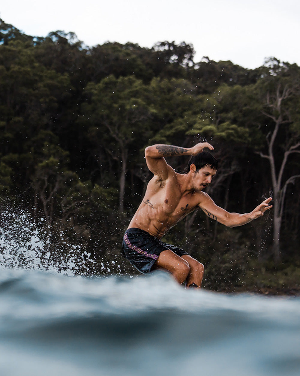 ripped and tattooed surfer