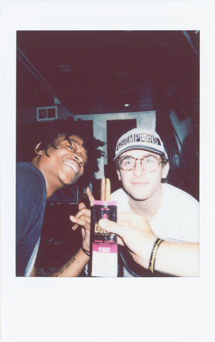 Two friends smiling in a polaroid picture.