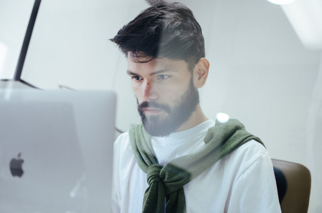 Man facing his laptop at work.