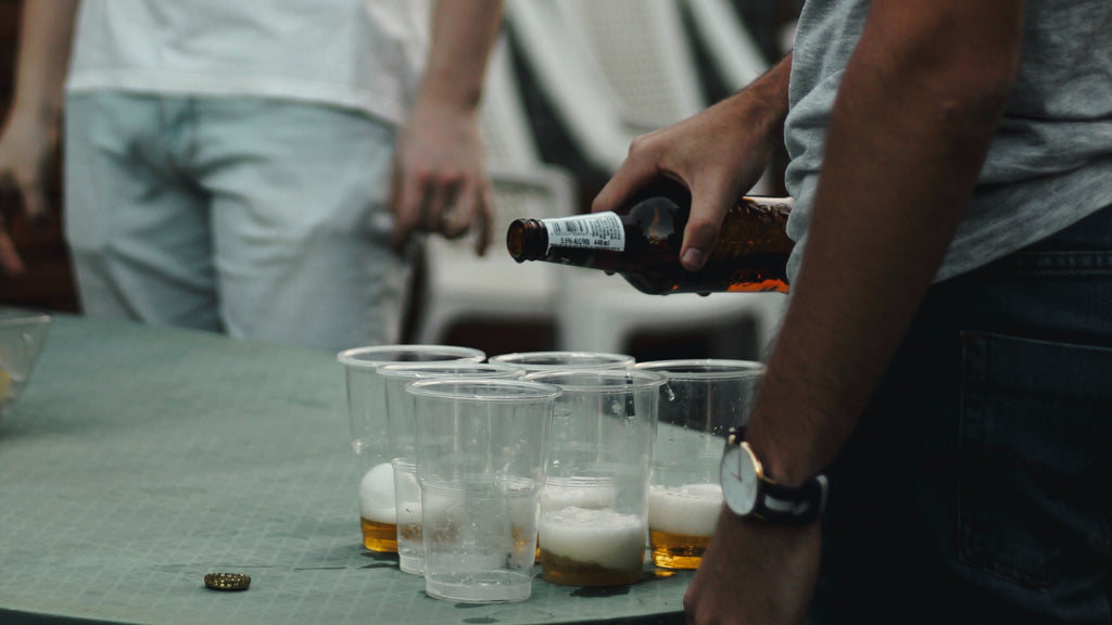 Men playing beer pong.