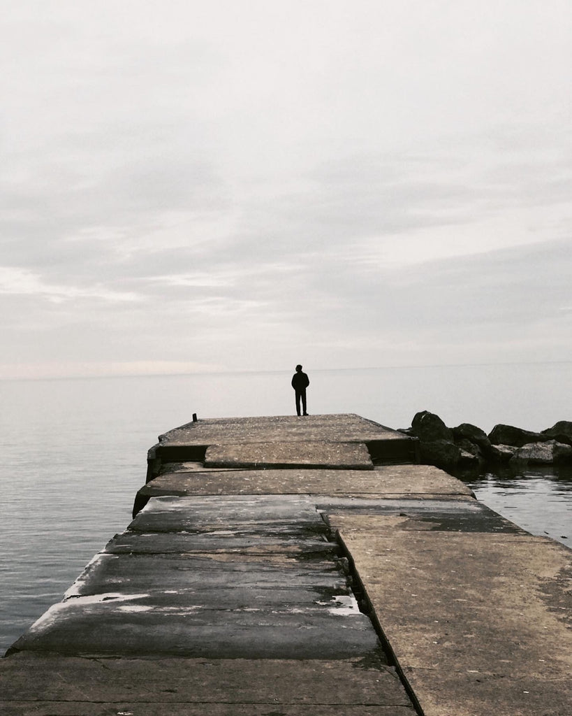 A man stands at the edge of the sea.