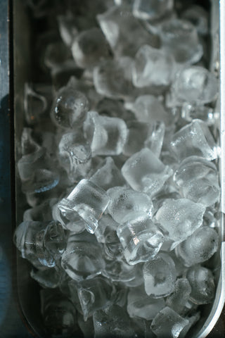 Ice cubes for acne in a glass with thyme oil for help
