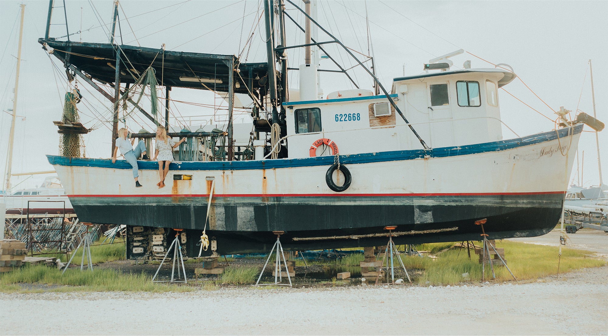 Women and the Wind sitting on side of boat