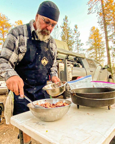 man wearing apron preparing food
