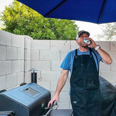 man drinking beer at the grill