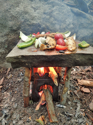 While camping or backpacking in the outdoors, the Stöker Flatpack Stove is used to fry vegetables with the use of a flat rock.
