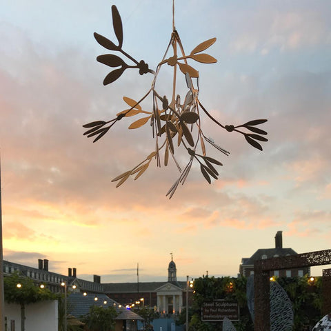 Image of mistletoe against a sunset sky, with the Chelsea Pensioner's Hospital in the background