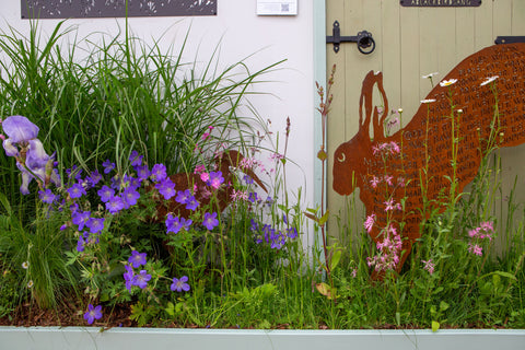 Image of leaping hare sculpture amongst wildflowers