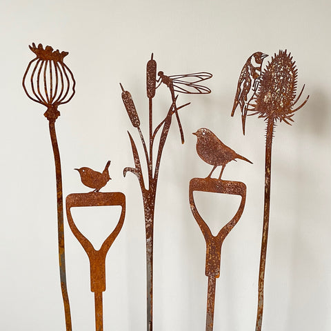 Image of five rusting Garden Stem designs against a white wall