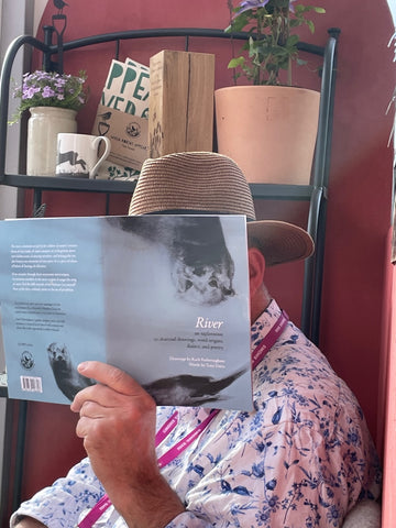 Image of a man (Tony) reading a book, his face masked by the book's cover