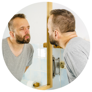 Man looking at face in the mirror