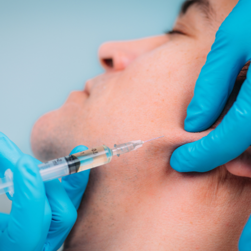 male jawline dermal filler injection with blue surgical gloves
