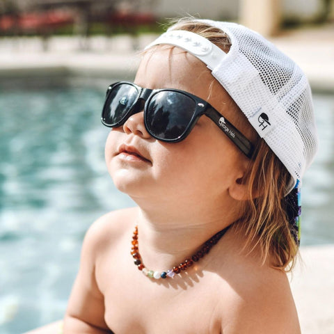 photo of little boy in black sunglasses and white hat