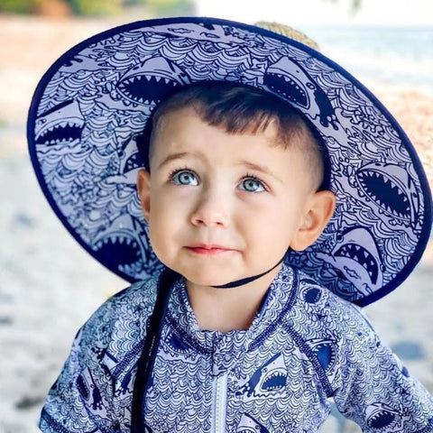 photo of young boy wearing a shark printed hat