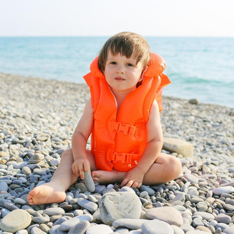 Young boy wearing a life jacket at the beach