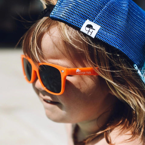 photo of boy in orange sunglasses and blue hat