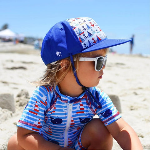 Young boy enjoying the beach in his blue striped sunsuit