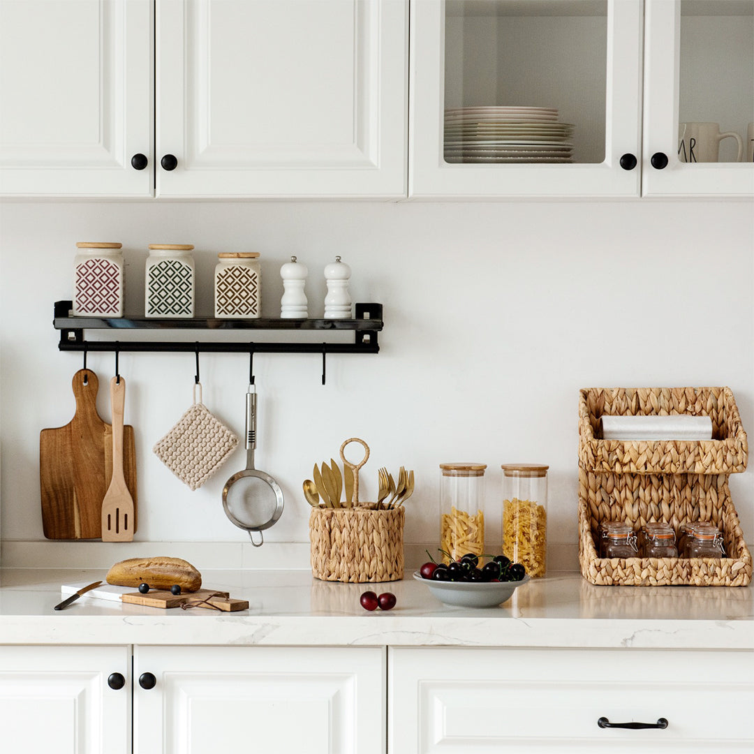 Handwoven wicker flatware organizer in a clean, well-organized kitchen countertop.