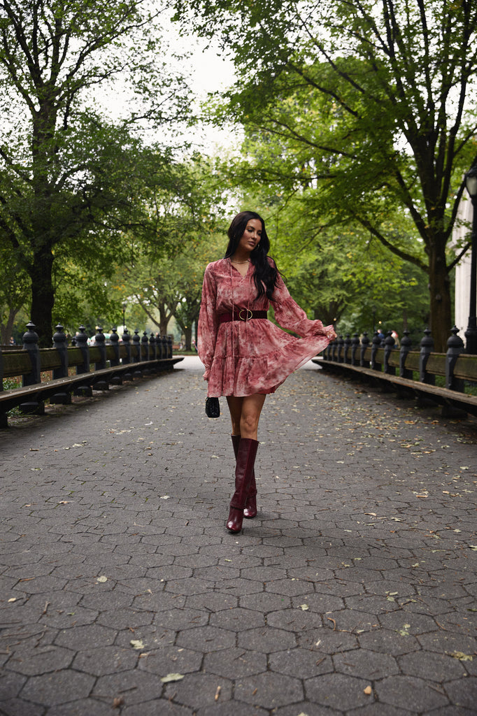 Rachel Parcell walking in Central Park, NYC holding hem of Pink Long Sleeve Mini Dress