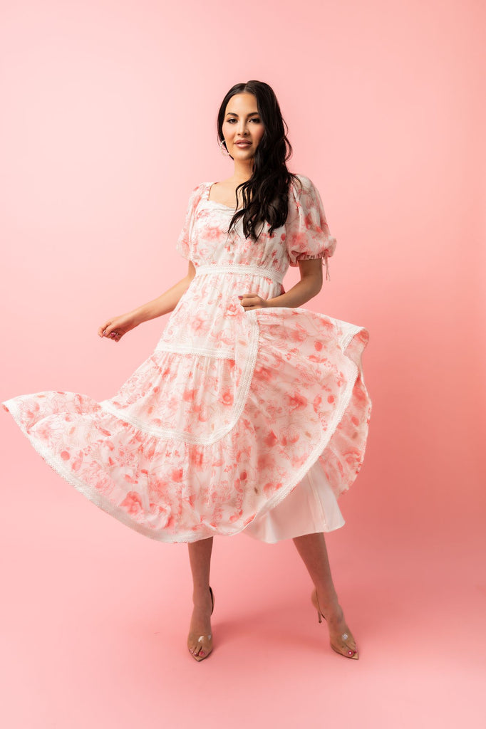 Rachel Parcell standing wearing Pink Floral Puff Sleeve Tiered Chiffon Midi Dress