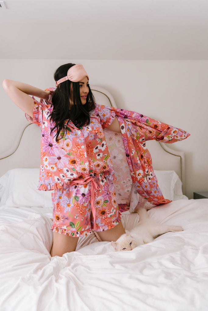 Rachel Parcell on bed wearing RP Floral Burst PJs and RP Floral Burst Robe