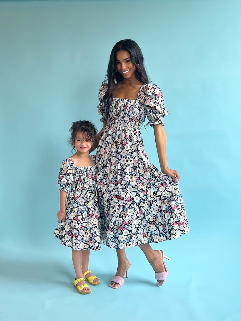 Mommy and Me models wearing Girls Puff Sleeve Retro Floral Dress and Retro Floral Tiered Midi Dress