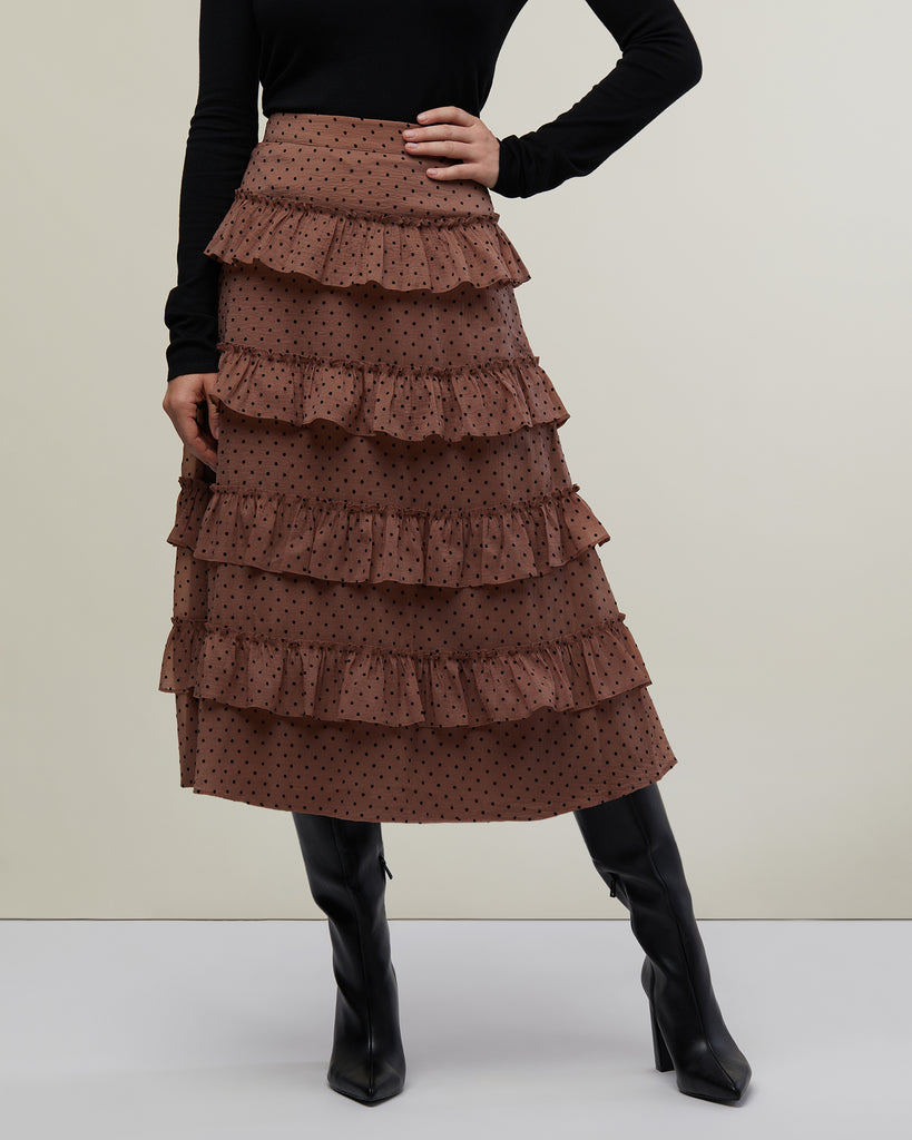 Close up image of model in photo studio posing with hand on hip wearing Nude and Black Polka Dot Tiered Ruffle Midi Skirt