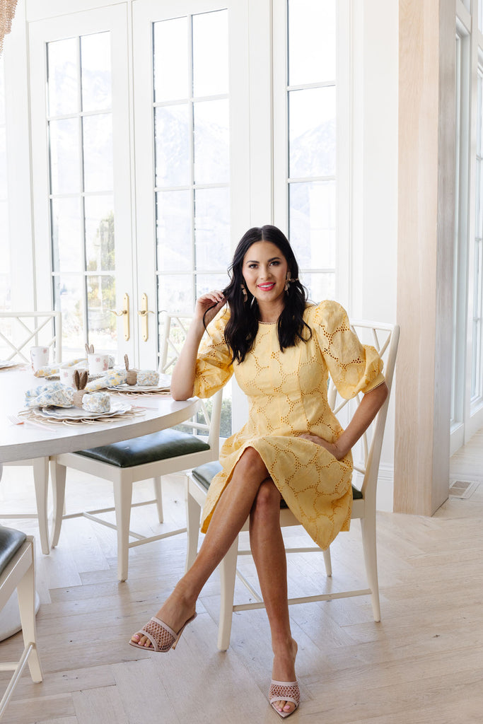 Rachel Parcell in her home wearing the RP Puff Sleeve Buttercup Eyelet Fit and Flare Dress