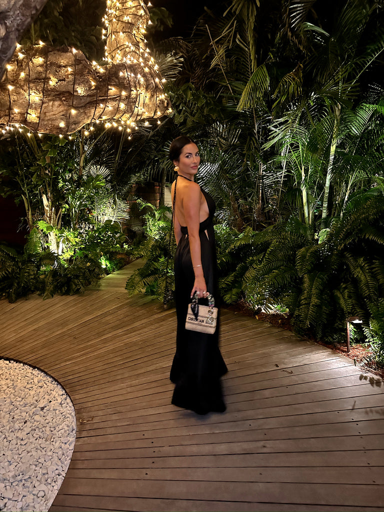 Rachel Parcell looking back at camera, standing outside of Tamarin restaurant in St Barths