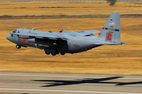 A C-130 Hercules, equipped with the modular airborne firefighting system, takes off from McClellan Airfield, California.