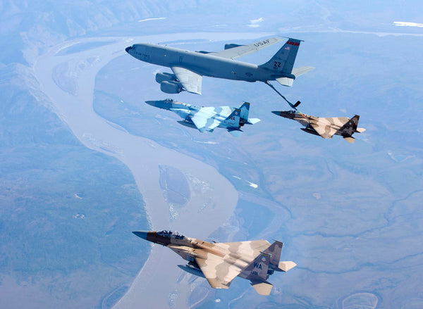 Three F-15 Eagles receive fuel from the Japan based 909th Air Refueling Squadron while flying over the Yukon River in Alaska.