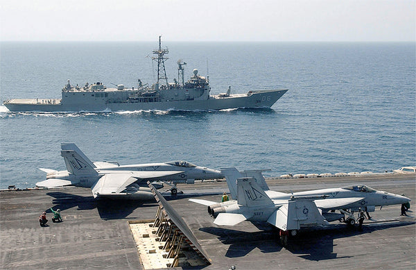 Two F/A-18 Hornets on the deck of an aircraft carrier