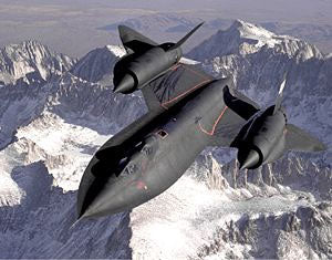SR-71 Blackbird flying over snow covered mountains.