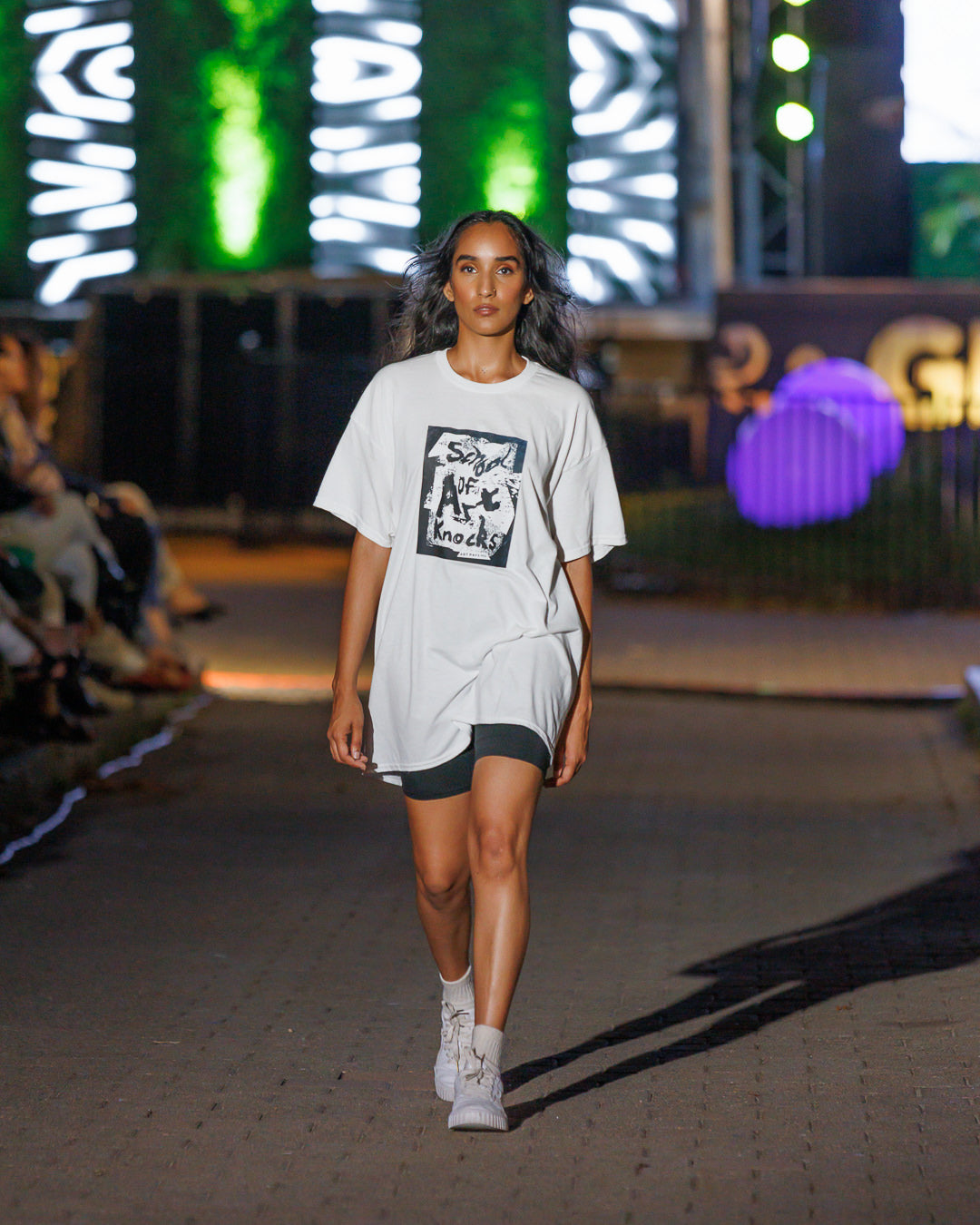 Woman wearing a white t-shirt with School of Art Knocks printed on the front