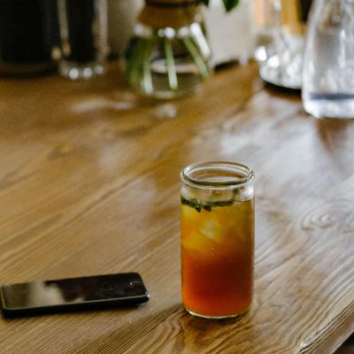 A transparent mason jar filled with cold tea.