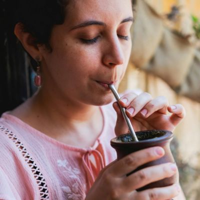 A woman enjoying sipping a gourd of Yerba Mate.