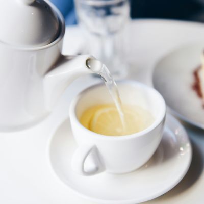 White tea being poured into a cup.