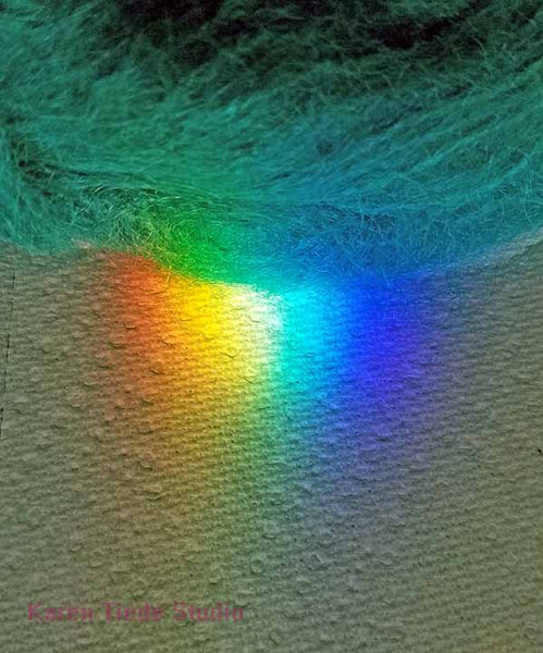 Testing teal mohair against a rainbow from a chandelier