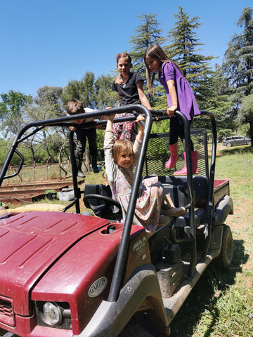 Family Friendly Farms at Our Lady's Ranch in Grass Valley, CA - a bunch of smiling kids using an ATV as a jungle gym.