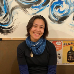 Christia Zeiter at age twenty-one in a restaurant in Tokyo, Japan where she has been teaching English. Smiling, dark-haired girl in a Japanese restaurant.