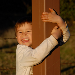 Joseph Zeiter at age four grinning and hugging the foot of the cross at Our Lady's Ranch in Northern, California.