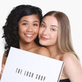 two girls hold a box that says the lash shop