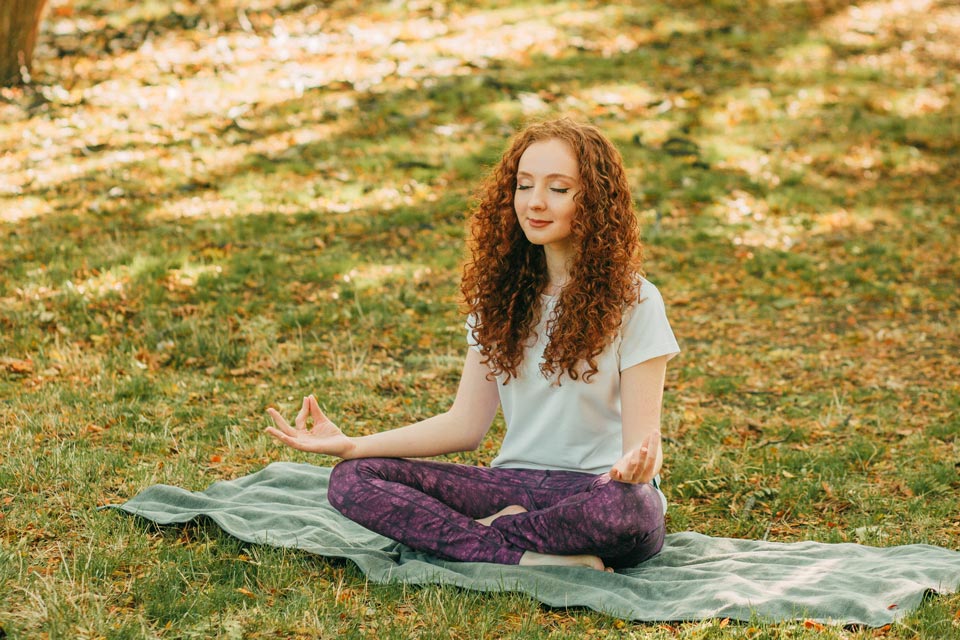 Young woman practicing mindfulness with yoga and meditation