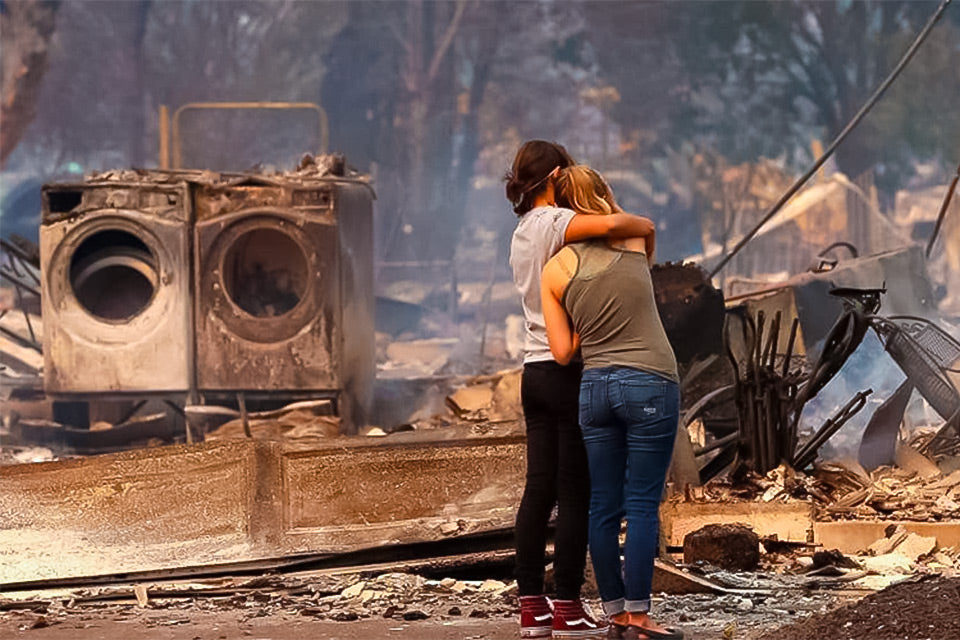 Image from the San Francisco Chronicle about the 2017 Tubbs Fire showing two women standing in front of a burned down house