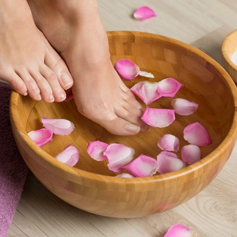 Feet in water with flower pedals